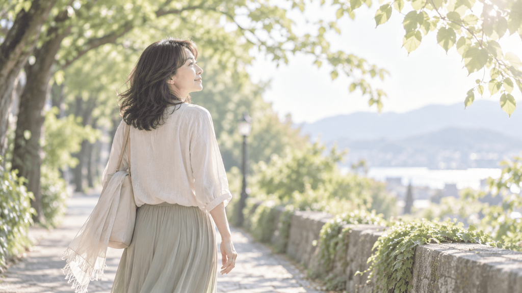 昔の思い出を振り返りながら木漏れ日の道を歩く女性